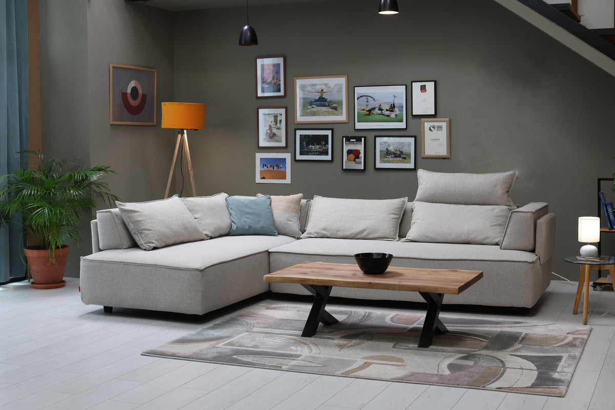 FEYDOM CasCais G Ecksofa vor einer Galeriewand mit gerahmten Bildern